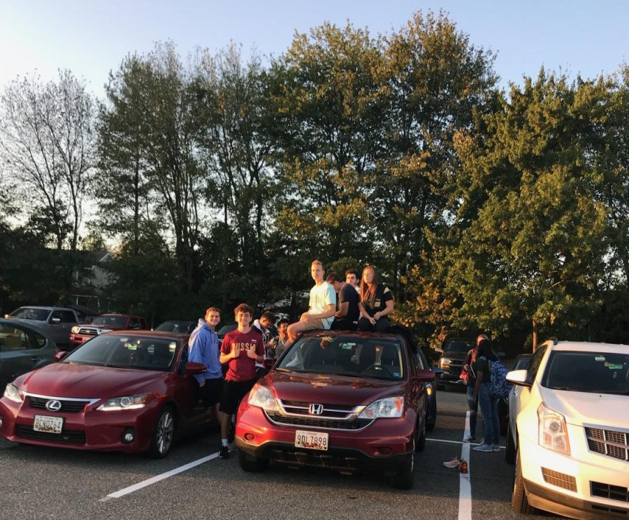 Students perch atop their cars during the Senior Sunrise. 