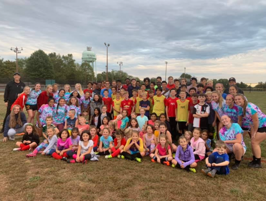 Boys and girls varsity soccer teams pose with the Junior Falcon athletes. 