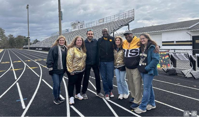 Staff members take pictures on the track for Feel Good Friday.